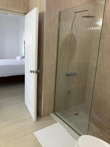 een douche met een glazen deur in een badkamer bij So Suite, Negril with seaview in Negril