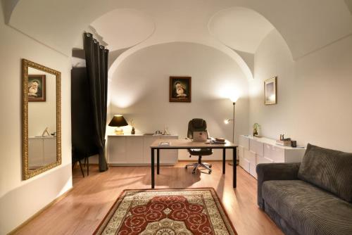 Golden goose في كوشيتسه: غرفة معيشة مع أريكة وطاولة مع الكمبيوتر المحمول