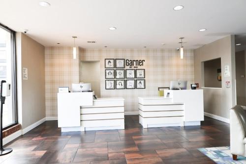 a salon with white furniture and a tile wall at Garner Hotel Glen Burnie BWI Airport Area by IHG in Glen Burnie