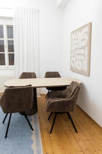 uma sala de jantar com mesa e cadeiras em Stylish Old Town Apartment with Infrared Sauna em Linz