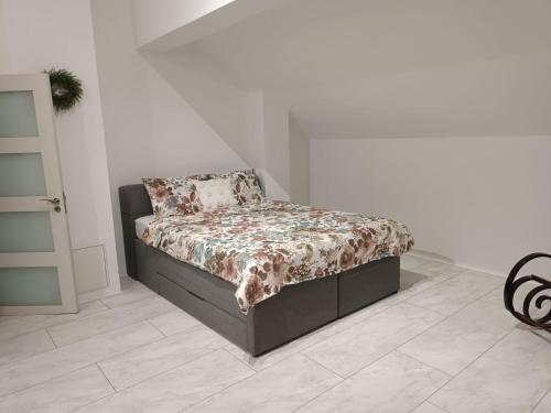 un letto in una stanza bianca con copriletto e cuscino di Popas 26 a Nădlac