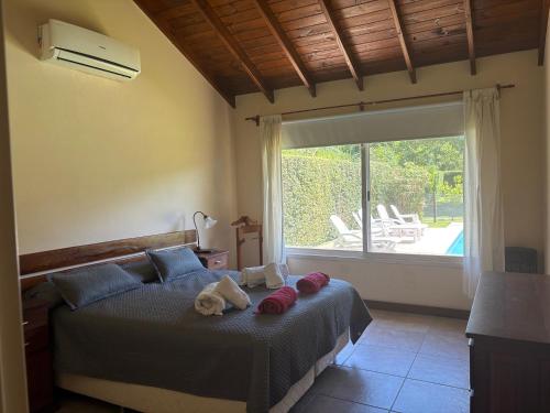 a bedroom with a bed with two stuffed animals on it at Casa en Ing. Maschwitz con gran parque y pileta in Ingeniero Maschwitz