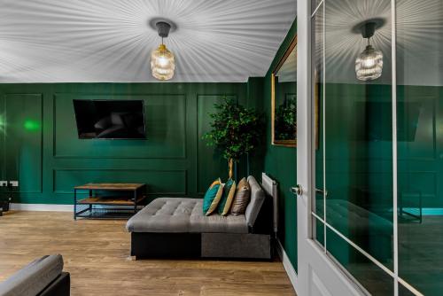een woonkamer met groene muren en een bank bij Spacious 5 Bed House in Reading by Amber Stays, Perfect for Business & Contractors, Sleeps 12 in Reading