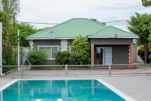 IJ Apartments في ندولا: منزل به حوض سباحة أمام المنزل