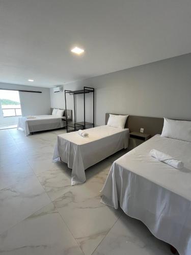 a hotel room with two beds in a room at Piúma Palace Hotel in Piúma
