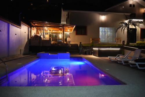 GualaceoにあるQuinta Nalligの青と紫の照明が灯る夜のスイミングプール