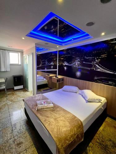 a bedroom with a large bed with a blue ceiling at Motel Segredos (Adults Only) in Guarulhos