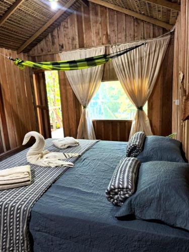 a bedroom with a bed with a swan on it at Hotel Arara Azul in Aiparuça