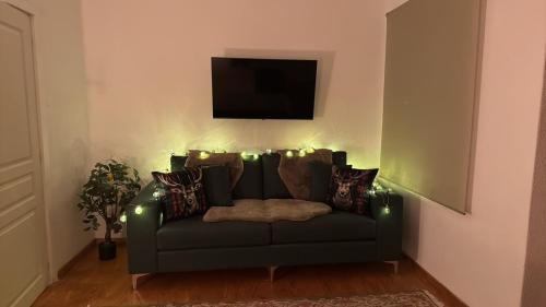 Una sala de estar con un sofá verde con luces. en MZ Maison de la Place, en Eptalofos