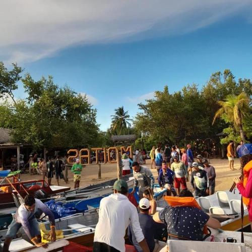 um grupo de pessoas trabalhando em barcos em uma praia em camping do point lá na barra em Amontada