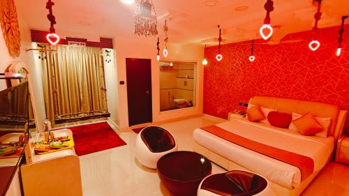 a bedroom with a bed and chairs and a bathroom at Spago Inn-Only for Families & Couples not for Bachelors in Mahabalipuram