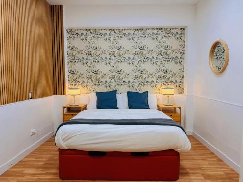 een slaapkamer met een groot bed met blauwe kussens bij Hola Rooms in Madrid