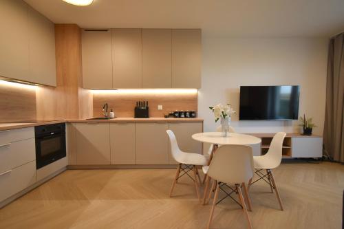 Szpitalna Residence & Garage في سووالكي: مطبخ مع طاولة وكراسي وتلفزيون