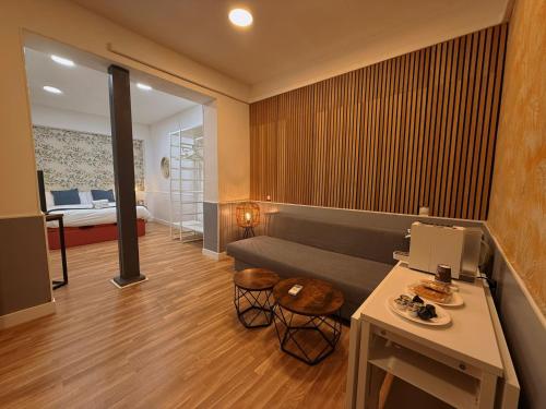 een woonkamer met een bank en een bed bij Hola Rooms in Madrid