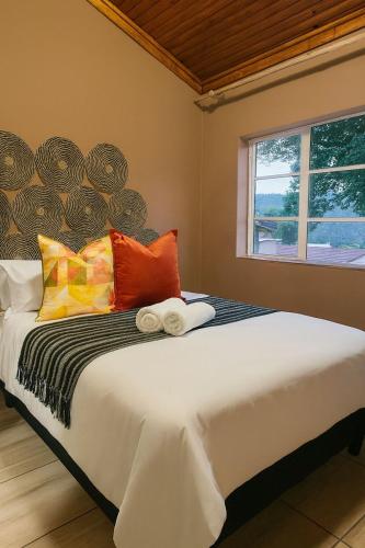a bedroom with a large bed with colorful pillows at Panaroma View in Graskop