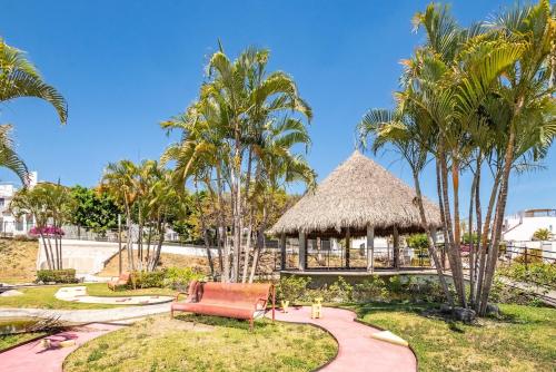 a gazebo in a resort with palm trees at Private Pool & Jacuzzi Family House, Teques in Tlatenchu