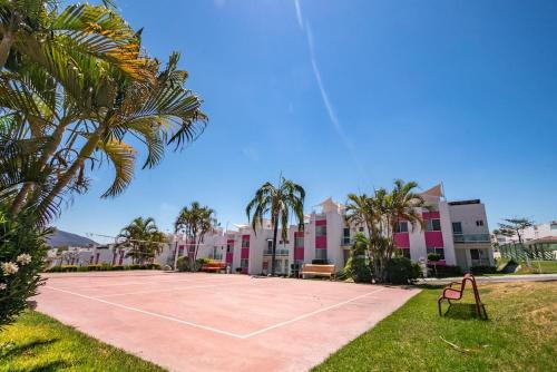 a tennis court in front of a building with palm trees at Private Pool & Jacuzzi Family House, Teques in Tlatenchu