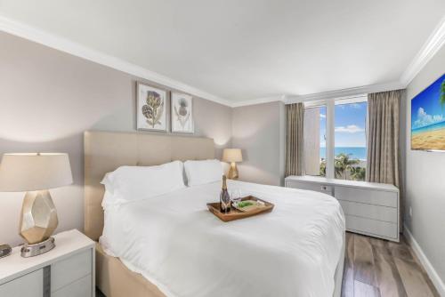 a bedroom with a white bed with a tray on it at Marco Beach Ocean Resort 910 in Marco Island