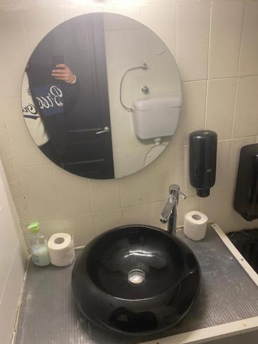 a man taking a picture of a black sink in a bathroom at Hotel ambra milano in Milan