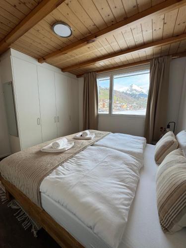 a large bed in a room with a large window at Louisa's Loft - Auszeit in den Bergen & der Natur für Familien, Freunde und Paare - Wandern & Seen - 1h ab Zürich in Alt Sankt Johann