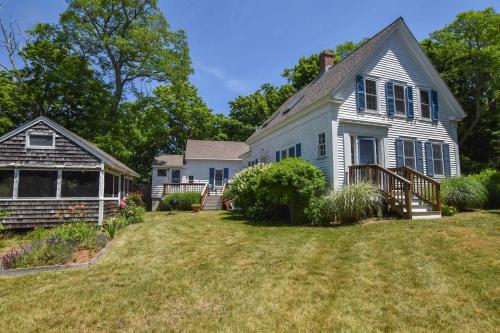 a white house with a porch and a yard at Private Downtown Wellfleet Location in Wellfleet