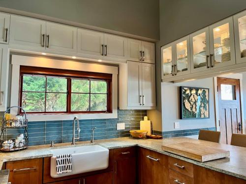 Ideal Beachfront Retreat Experience Gorgeous! في فرايداي هاربور: مطبخ بخزائن بيضاء ومغسلة