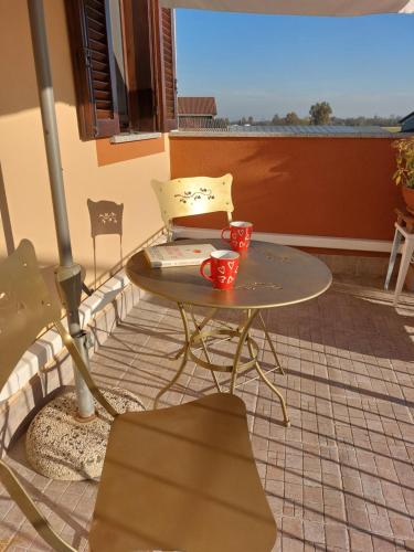 Casa nonna Gina في سان فرانشيسكو أل كامبو: طاولة على شرفة عليها كوبين باللون الأحمر