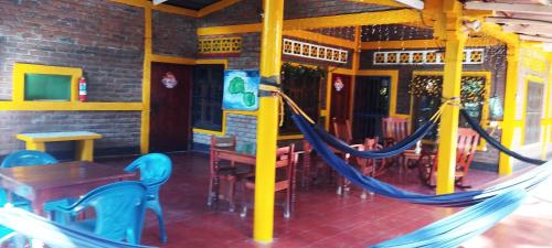 a hammock in a restaurant with tables and chairs at El Güis hostel in Balgue