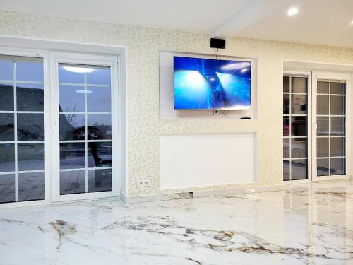 A&G SoDYBA LIUXAPARTAMENT في بلونج: غرفة بيضاء مع تلفزيون على الحائط