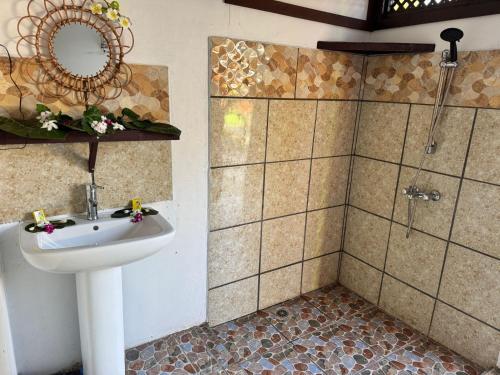 a bathroom with a sink and a shower at Motu Tahuhu Lodge in Rangiroa