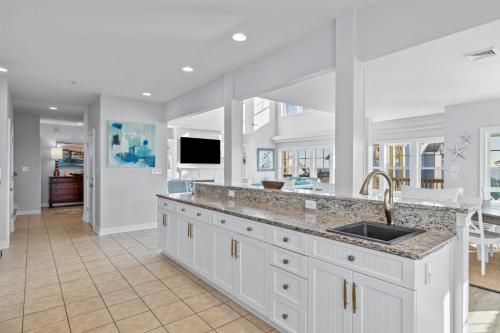 a kitchen with white cabinets and a sink at Penthouse in Atlantic Beach