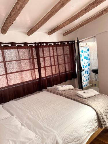 ein Schlafzimmer mit einem Bett, auf dem zwei Handtücher liegen in der Unterkunft ENEDE HOSTEL in Cusco