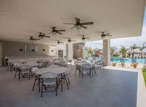 Los BledalesCasa Del Sol的有桌椅和游泳池的宴会厅