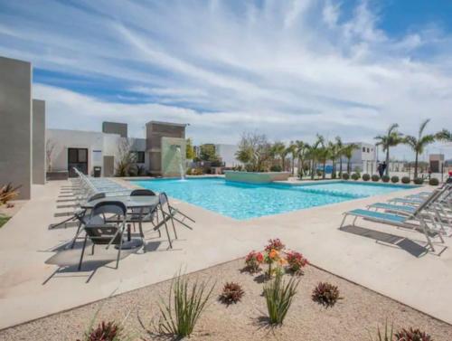 Los BledalesCasa Nopal的旁边有桌子和椅子的游泳池