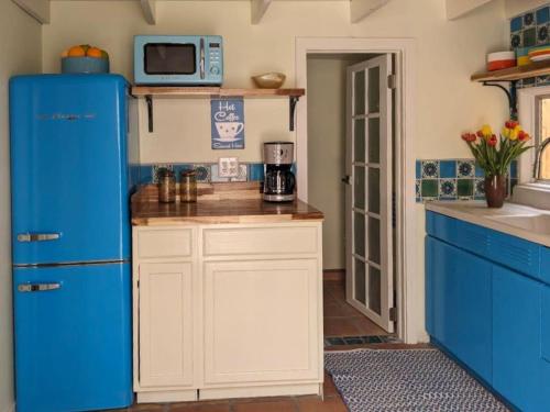a kitchen with a blue refrigerator and a microwave at Mid-century marvelous 1 bed, pets welcome in Las Cruces