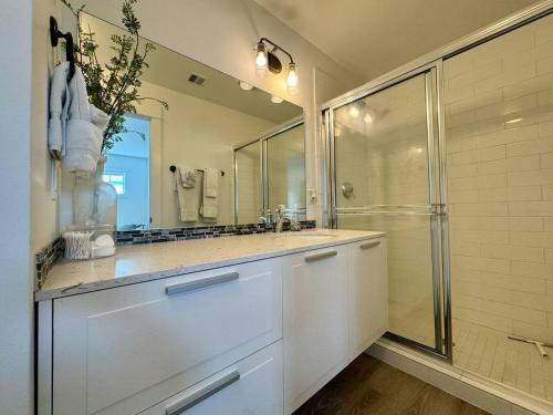 a white bathroom with a shower and a sink at Honeysuckle Beach Oasis at Veranda Beach in Oroville