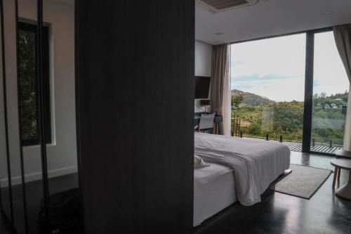 a bedroom with a bed and a large window at Barad Lux Villa in Mae Haad