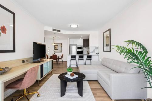 a living room with a white couch and a table at Stylish 2BR Retreat in Heart of Darling Harbour! in Sydney