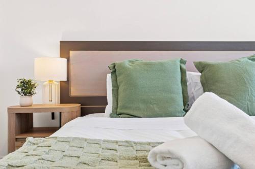a bedroom with a bed with green pillows at Stylish 2BR Retreat in Heart of Darling Harbour! in Sydney