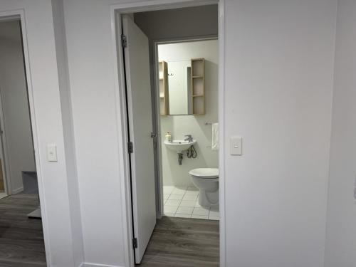 a bathroom with a toilet and a sink at Charming & Cozy Apartment in the Heart of Auckland - 2 bd-2 bth-free carpark in Auckland