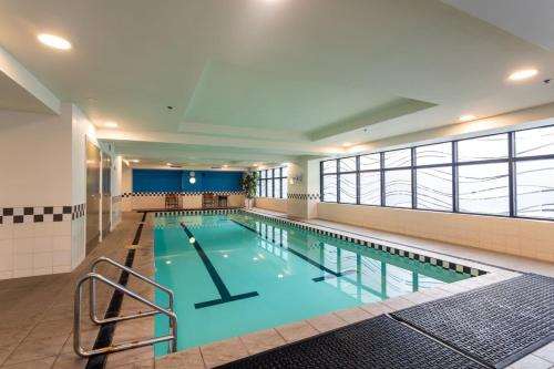 a large swimming pool in a building at Chic Hotel Room at City Life Auckland in Auckland