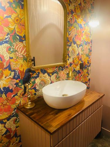 a bathroom with a sink and a mirror on a counter at Le Nid des Cardamines in Sainte-Eusoye