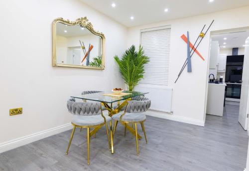 a dining room with a glass table and chairs at Paradise Nestv in Manchester
