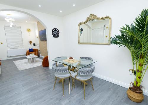 a dining room with a table and chairs and a mirror at Paradise Nestv in Manchester