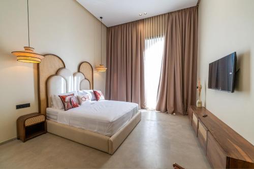 a bedroom with a bed and a flat screen tv at Berber Garden in Aït Amara