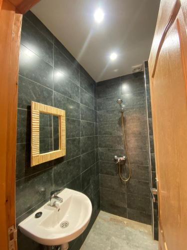 een badkamer met een wastafel en een douche bij Breeze surf lodge in Tamraght Ouzdar