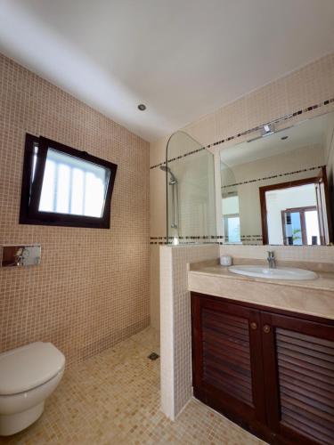 a bathroom with a toilet and a sink and a mirror at CuevaBlanca in Güime