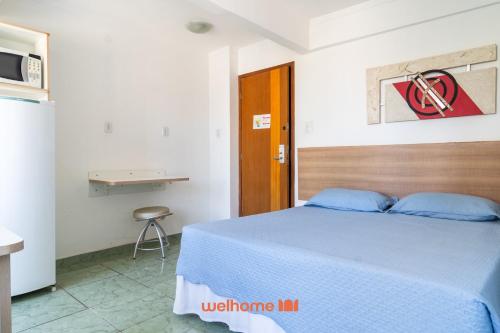 a bedroom with a blue bed and a desk at Apartamento em Macae no Centro da Cidade in Imbetiba
