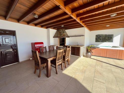 a kitchen and dining room with a table and chairs at CuevaBlanca in Güime