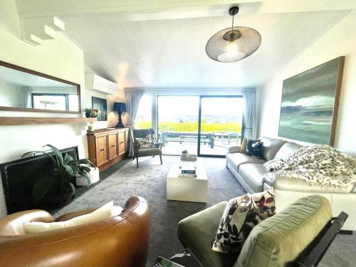 a living room with a couch and chairs at Iconic Taupō Views in Taupo